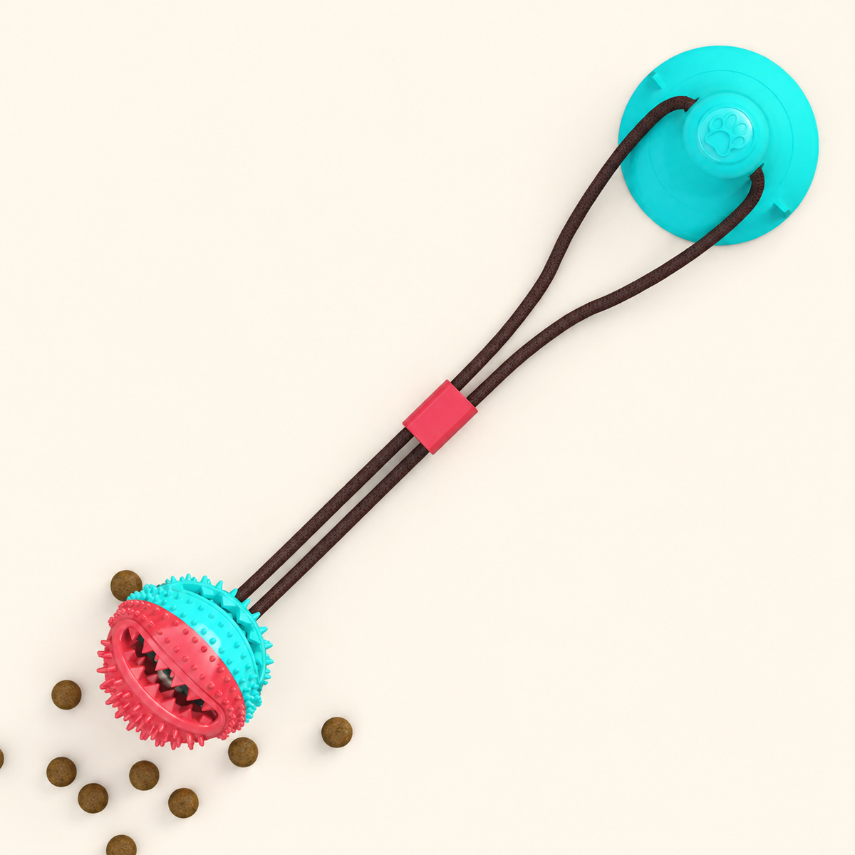 Blue suction cup dog tug toy with dual dark cords and a pink-and-blue textured round chew head on a warm ivory background.
