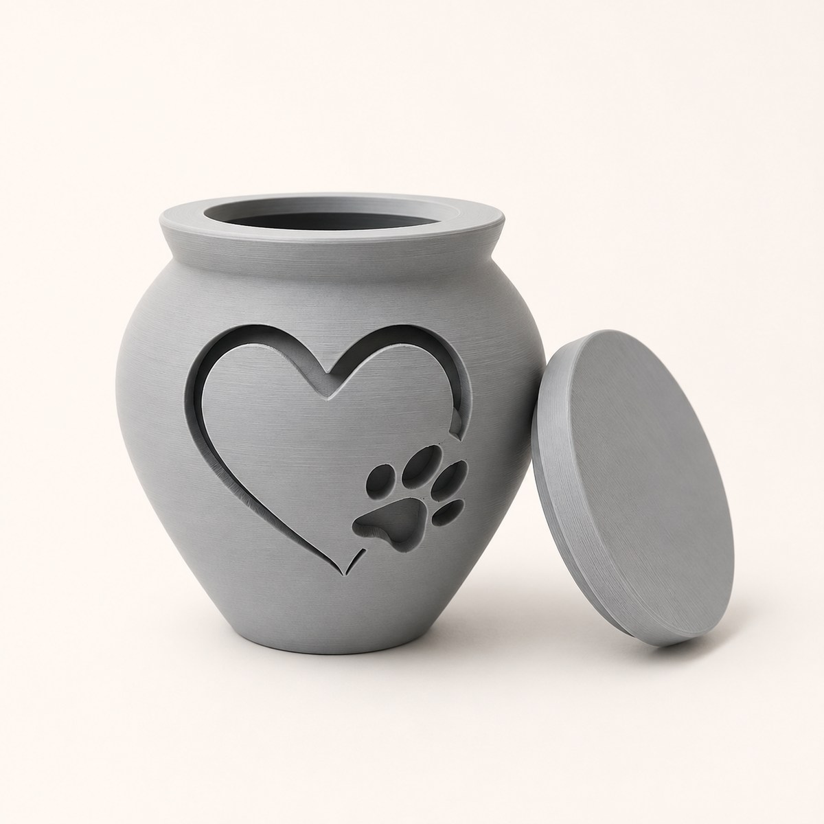 Light gray 3D printed pet memorial urn with large heart and paw print motif, lid removed.