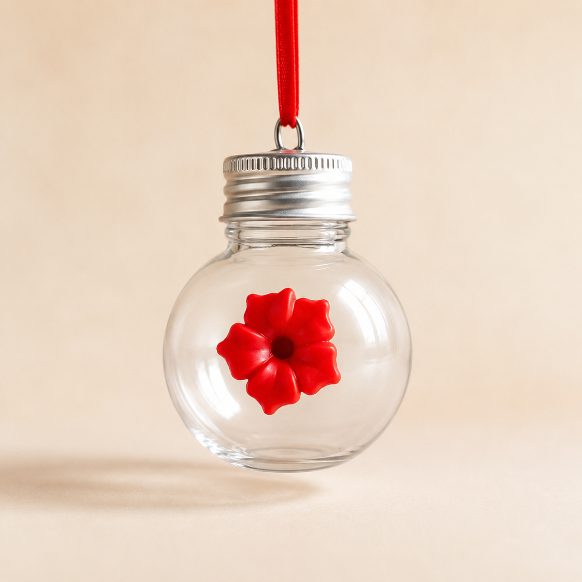 Product photo of the Bloom & Sip light bulb hummingbird feeder with clear hanging globe and one red floral feeding port.