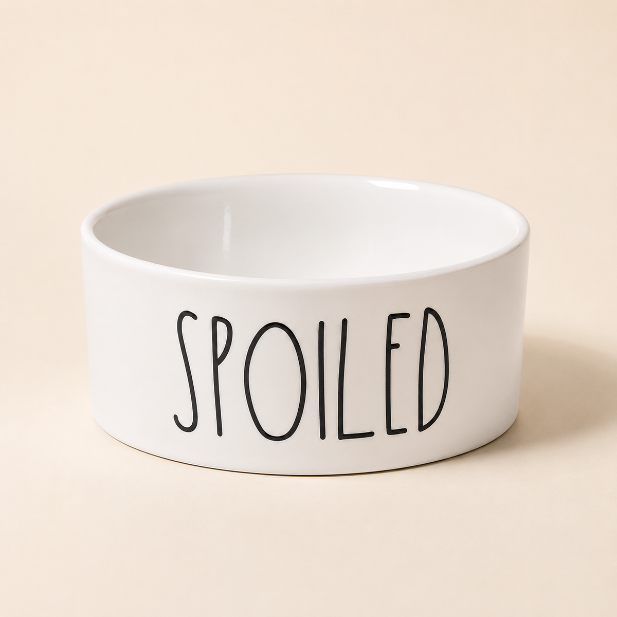 White Spoiled ceramic pet bowl with glossy white interior and black lettering in a premium studio product shot.