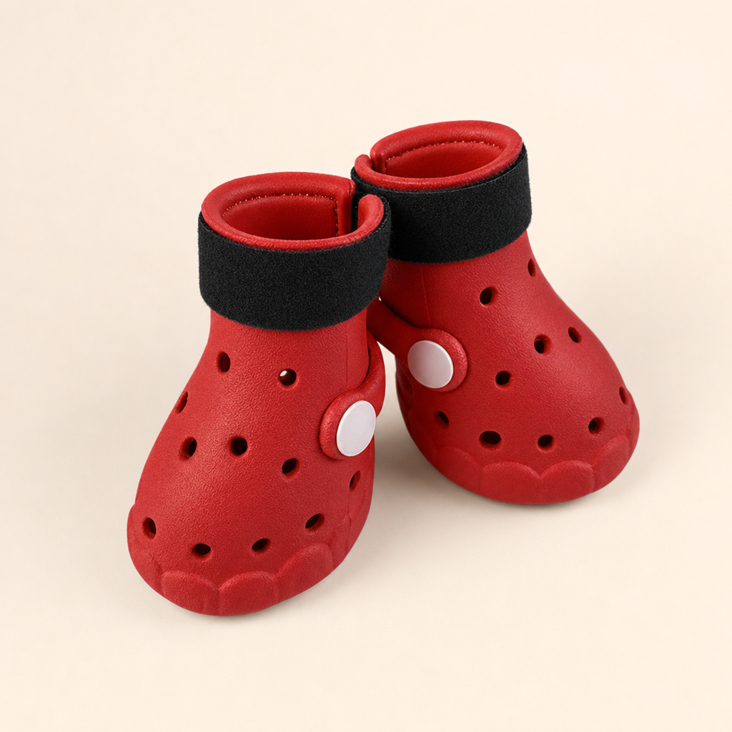 Two red EVA dog boots with black hook-and-loop straps and white side studs, on an ivory background.