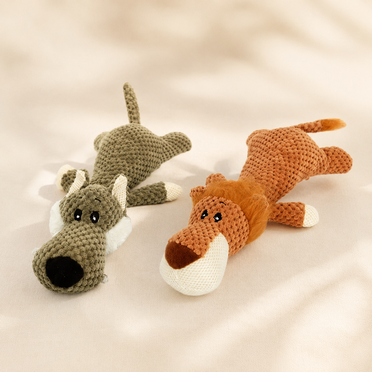 Hero image showing the Lying Wolf and Lying Lion plush dog toys together on a refined beige background.