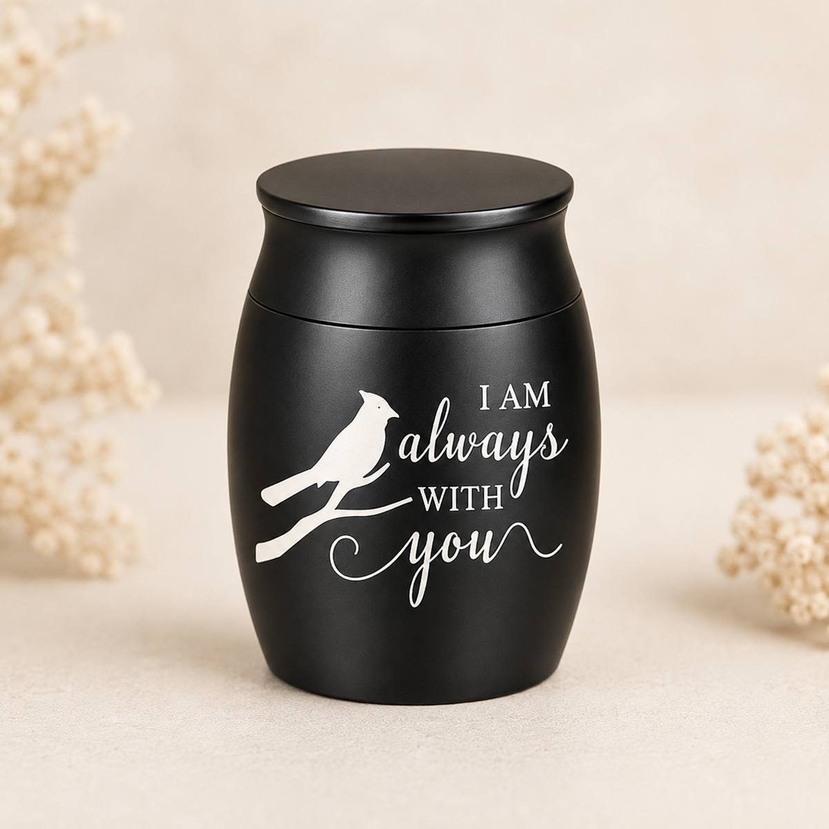 Matte black mini bird memorial keepsake urn with white cardinal motif and "I AM always WITH you" script on a neutral studio background.