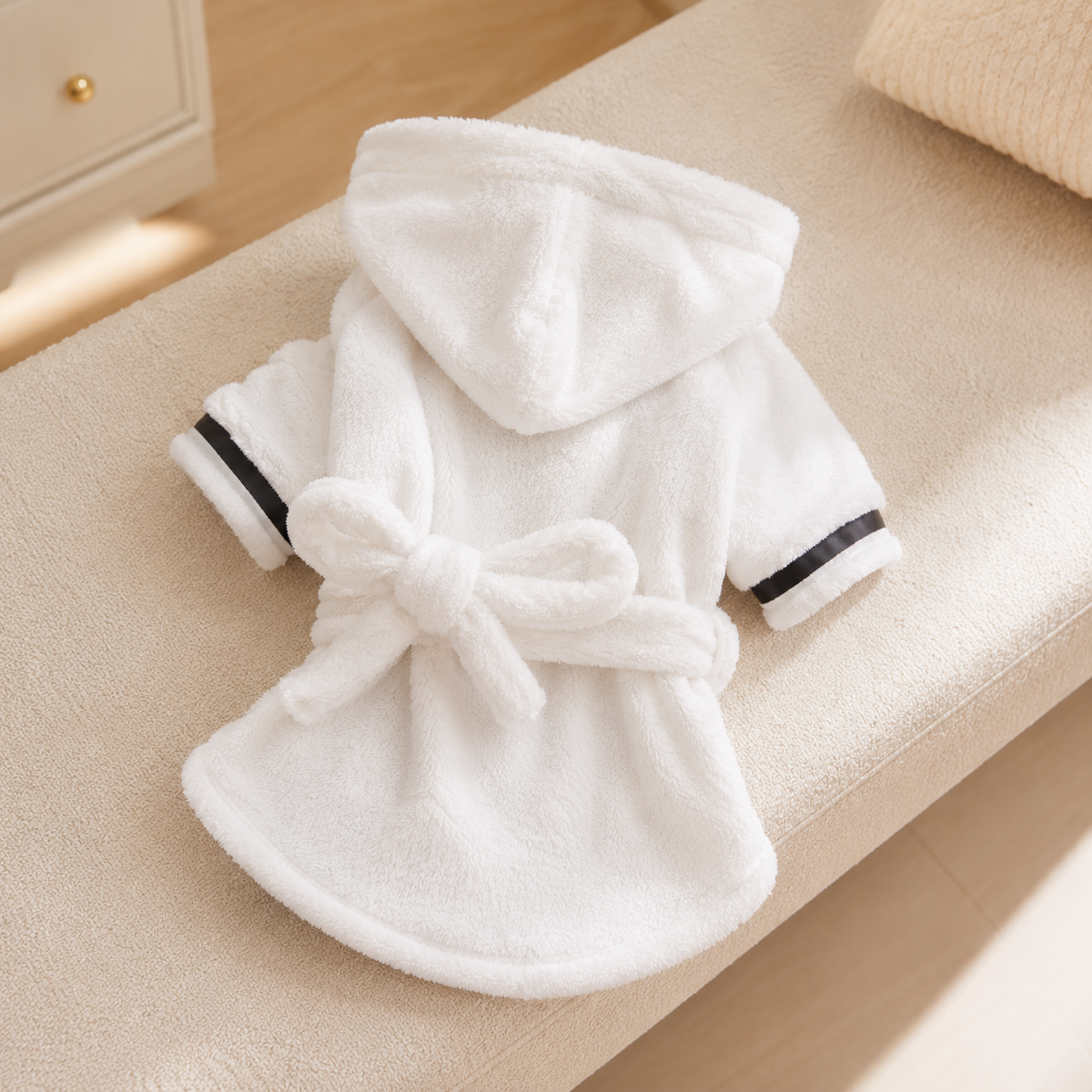 White coral fleece hooded dog bathrobe displayed in a warm neutral interior